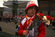 1989: A young unhappy Liverpool supporter carries some flowers in his team’s colours to lay in tribute after the Hillsborough disaster at Anfield in Liverpool, England. Mandatory Credit: Pascal Rondeau/Allsport